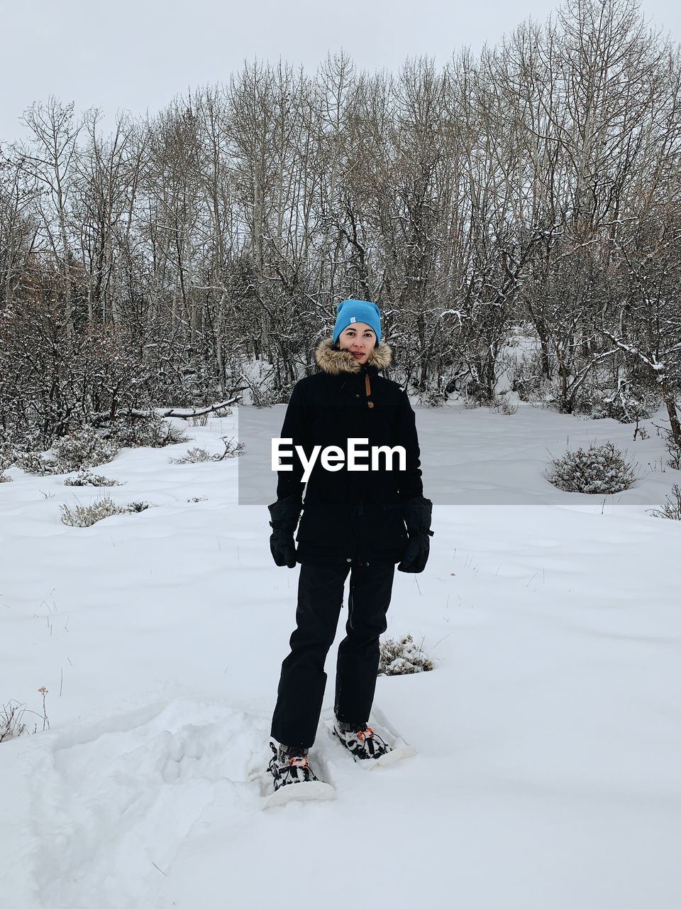 FULL LENGTH OF PERSON STANDING ON SNOW COVERED FIELD
