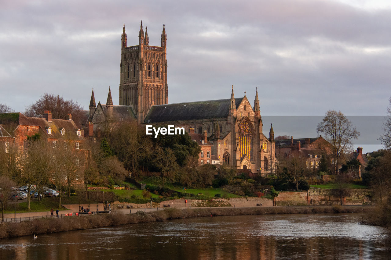 Buildingcathedral at waterfront against cloudy sky