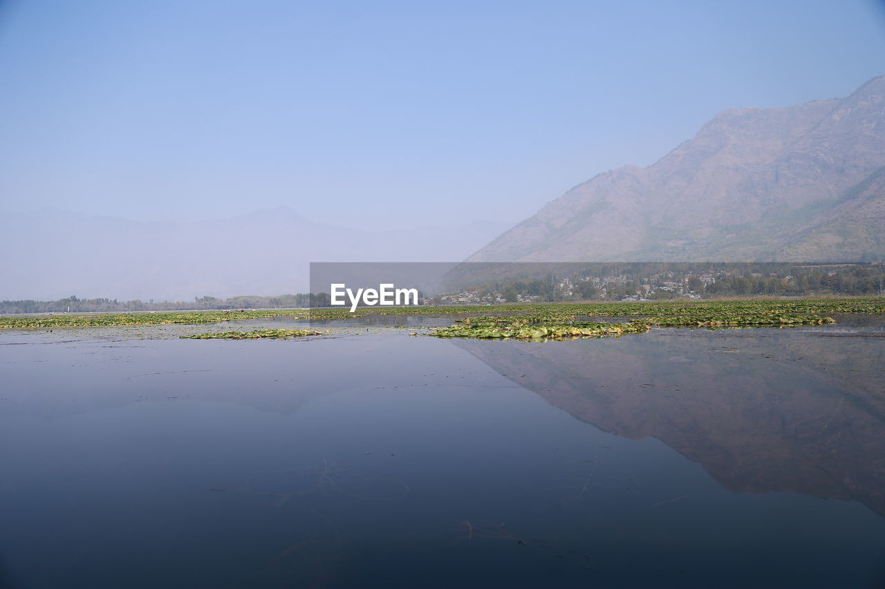 SCENIC VIEW OF LAKE BY MOUNTAIN AGAINST SKY