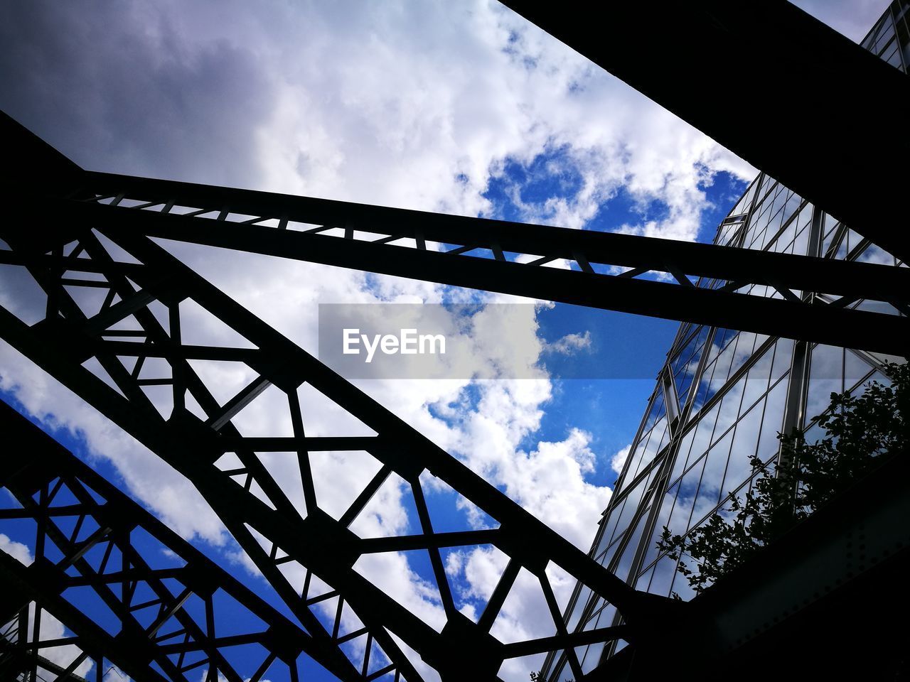 LOW ANGLE VIEW OF SUSPENSION BRIDGE AGAINST CLOUDY SKY