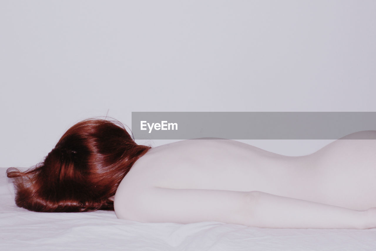 Redhead woman lying on bed