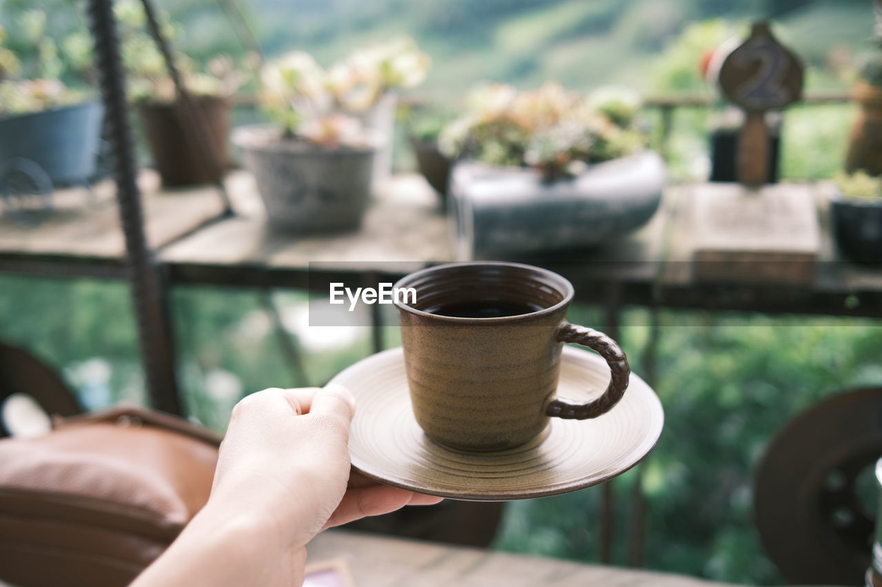 Person holding coffee cup on table