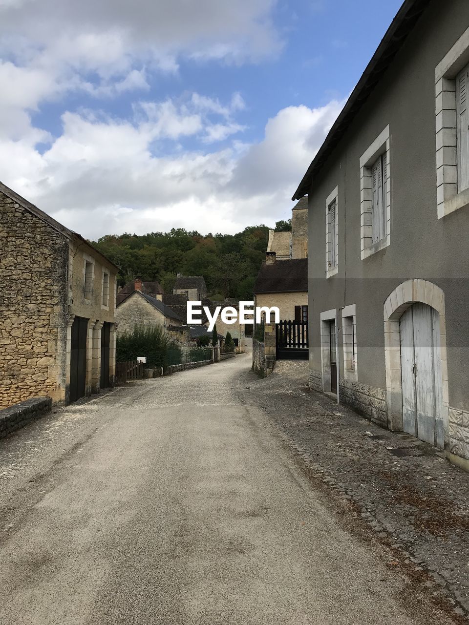 Empty road amidst buildings against sky