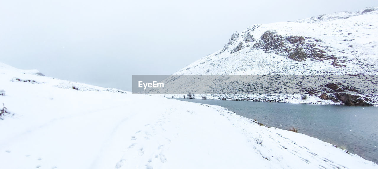 SNOW COVERED LANDSCAPE AGAINST SKY