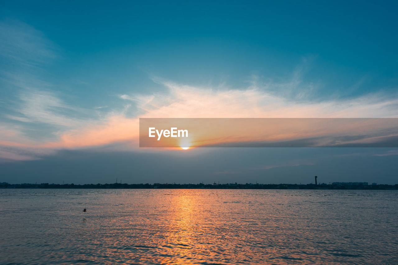 Scenic view of river against sky during sunset