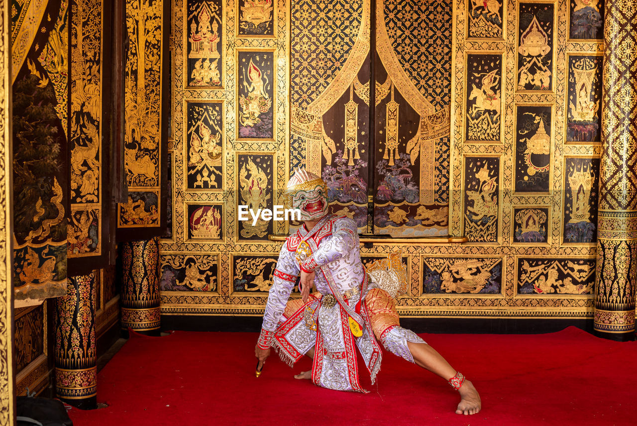 LOW ANGLE VIEW OF WOMAN IN TRADITIONAL CLOTHING AT HOME