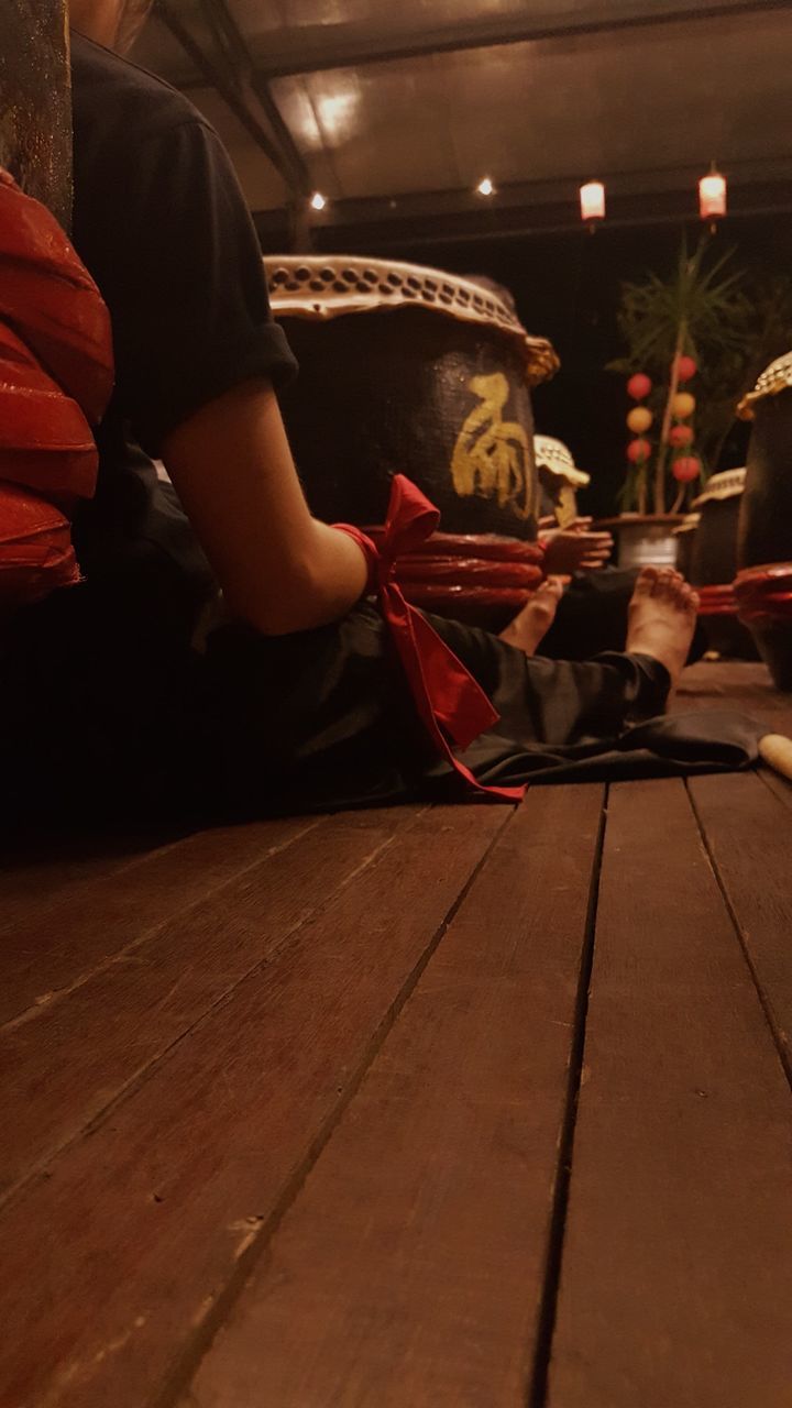 SIDE VIEW OF MAN SITTING ON ILLUMINATED FLOOR