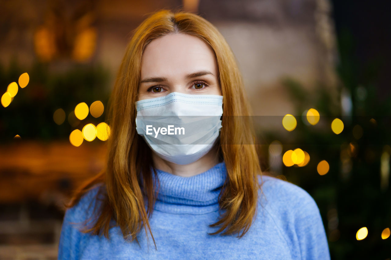 Portrait of beautiful woman wearing mask standing outdoors