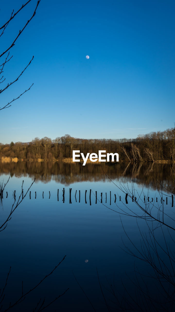 Scenic view of lake against clear blue sky