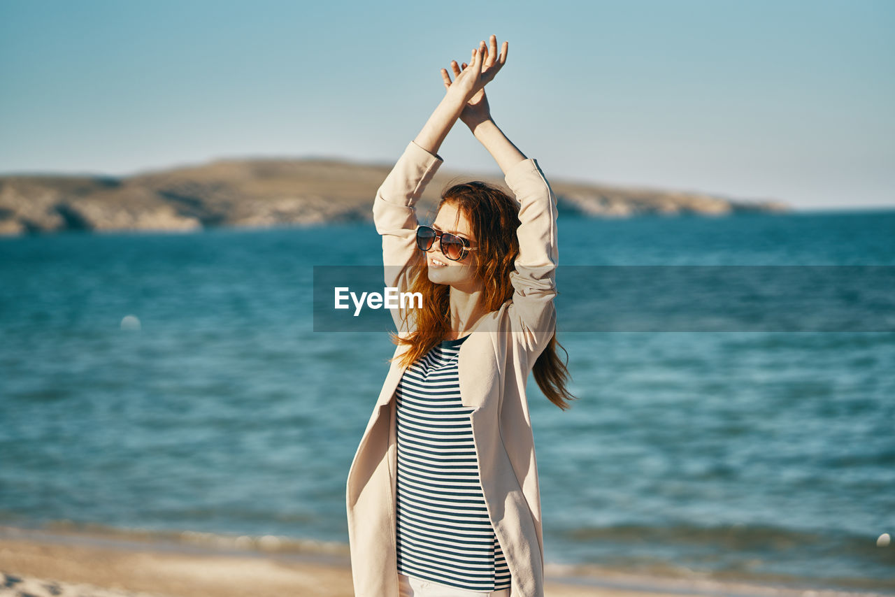 WOMAN STANDING ON BEACH