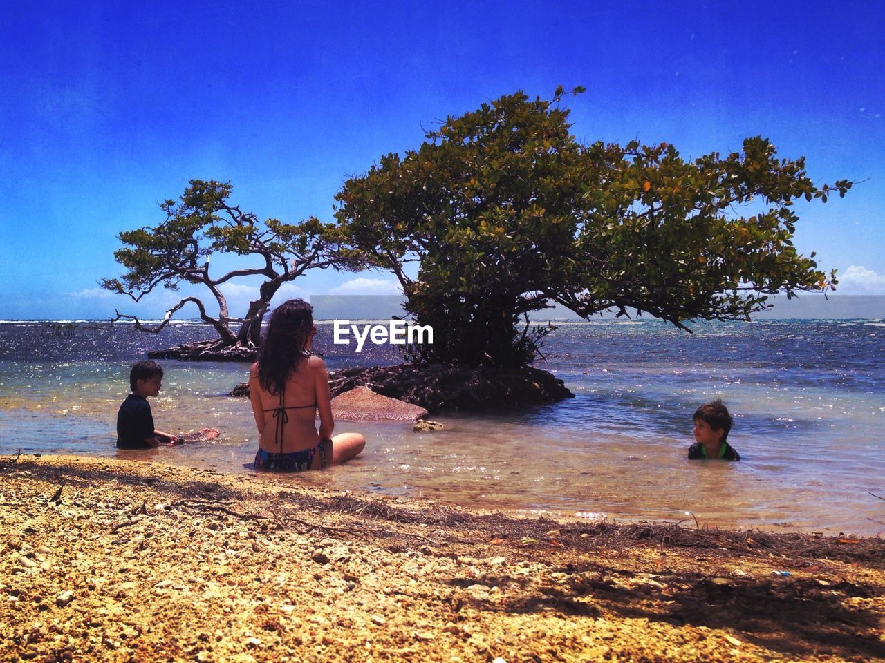 Boys with mother swimming in sea