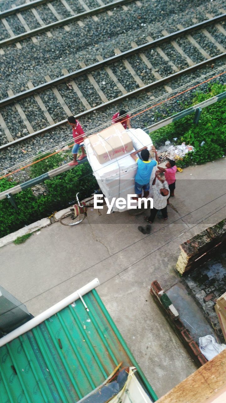 HIGH ANGLE VIEW OF PEOPLE WORKING ON RAILROAD TRACK