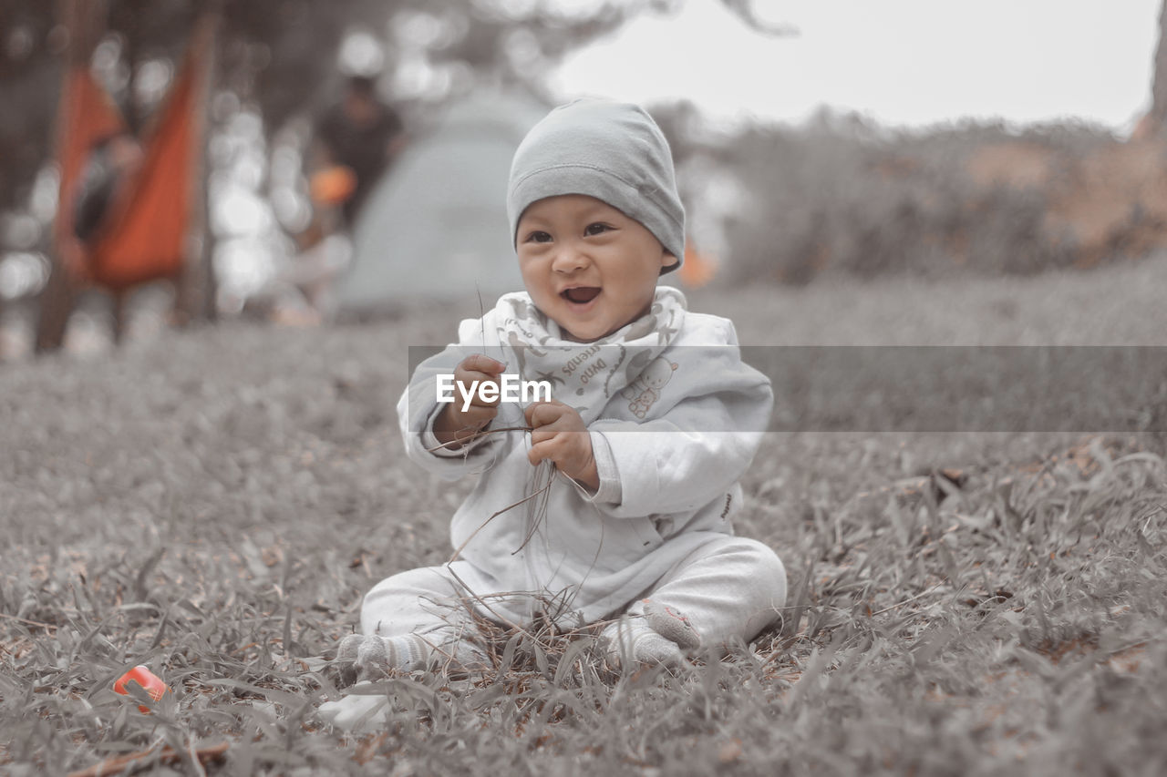 Full length of cute baby boy on field