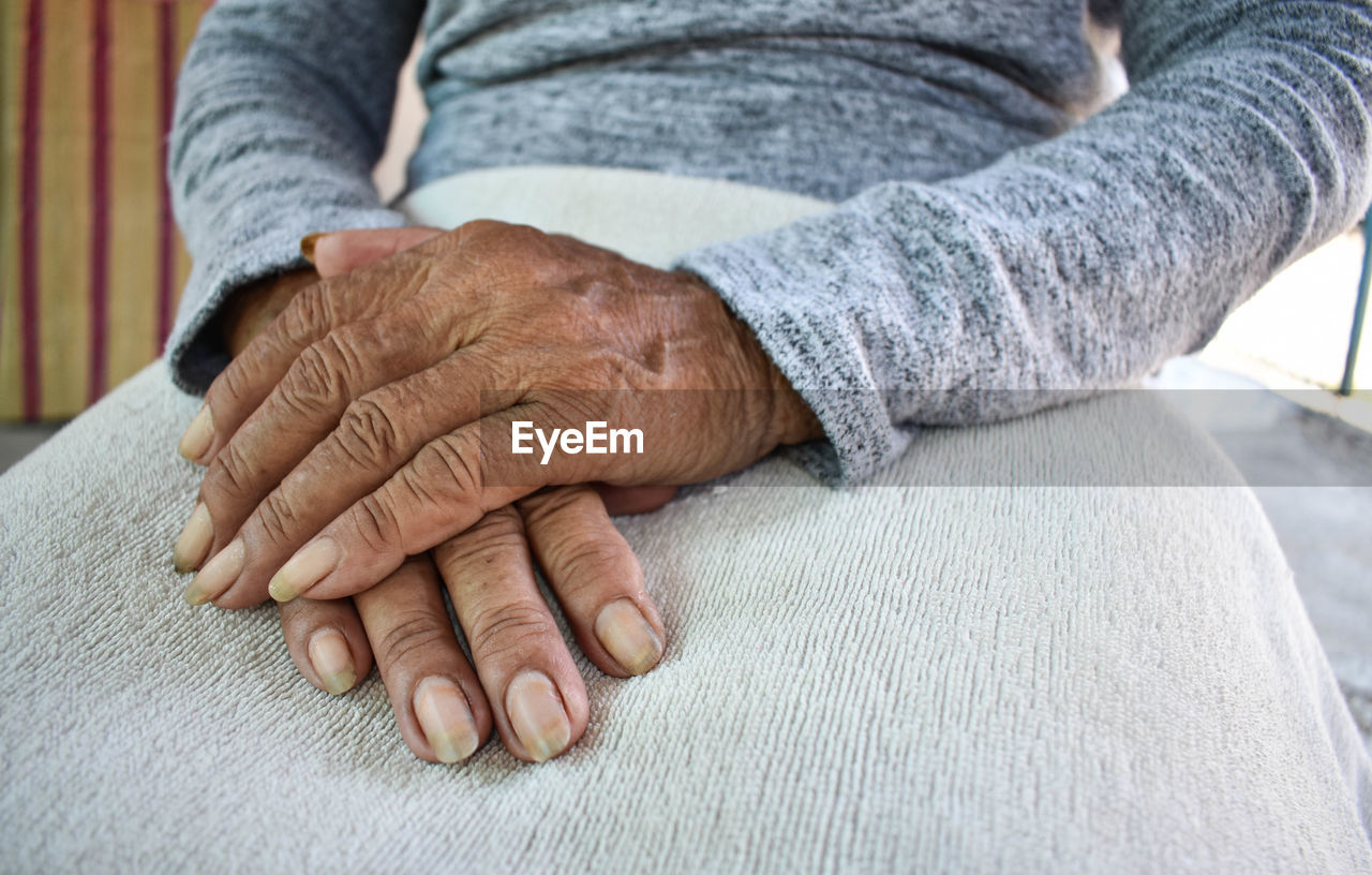Midsection of woman with hands clasped