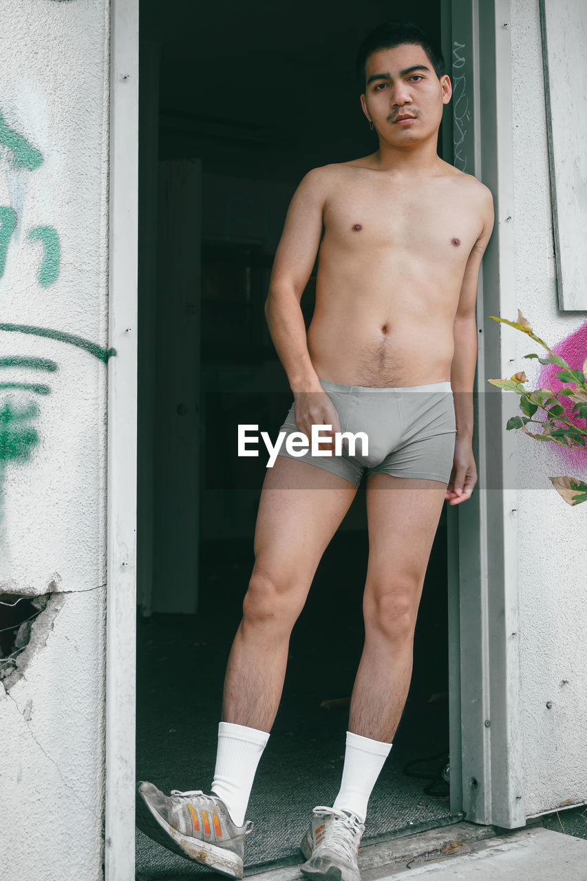 men, one person, clothing, young adult, adult, portrait, full length, limb, barechested, standing, fashion, human leg, person, looking at camera, lifestyles, door, entrance, front view, shorts, architecture, footwear, day, briefs, spring, underpants, leisure activity, photo shoot, muscular build, outdoors, cool attitude, undergarment