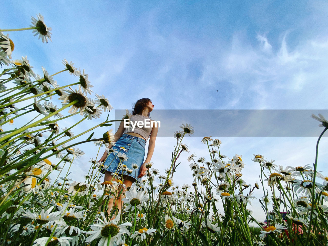 Low angle view of woman walking on field against sky