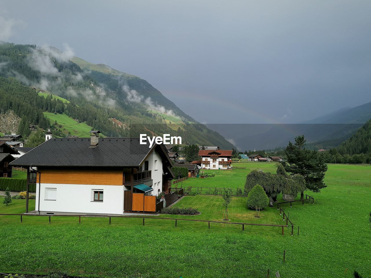 HOUSE ON FIELD AGAINST SKY