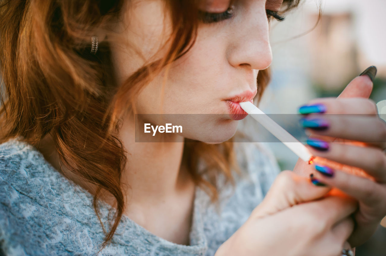 Close-up of beautiful woman smoking cigarette