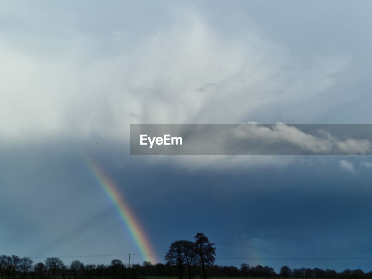 rainbow, cloud, sky, beauty in nature, tree, environment, scenics - nature, plant, nature, storm, multi colored, landscape, tranquility, no people, storm cloud, tranquil scene, dramatic sky, rain, natural phenomenon, idyllic, land, non-urban scene, thunderstorm, outdoors, overcast, wet, day, double rainbow, low angle view