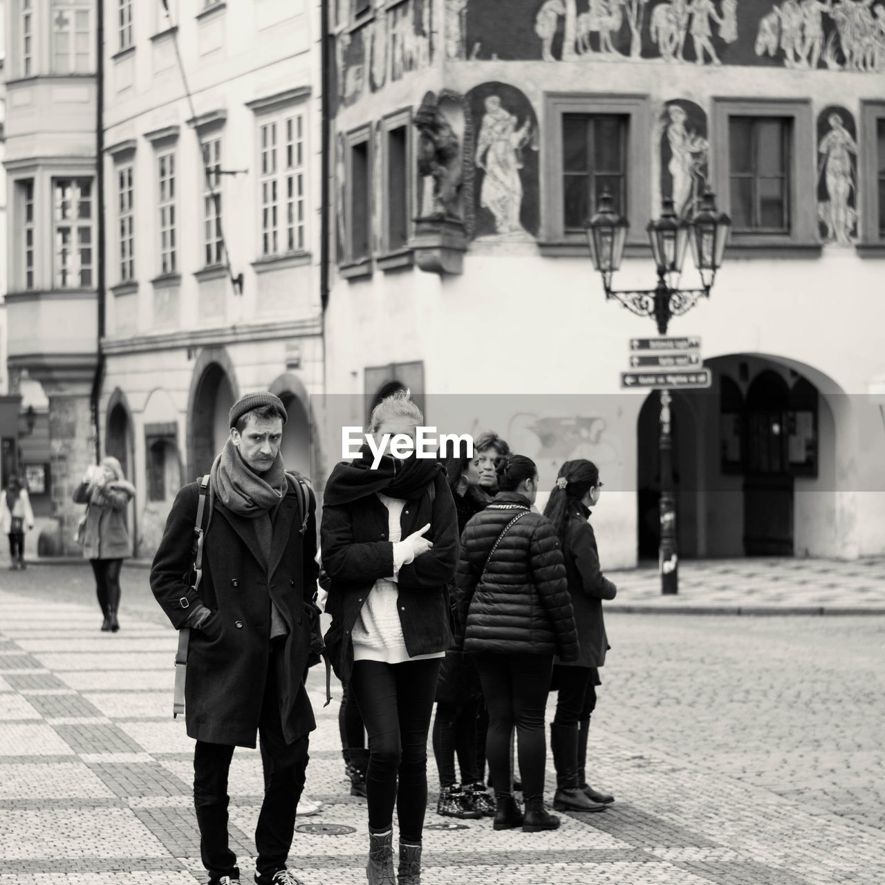 REAR VIEW OF PEOPLE WALKING ON STREET