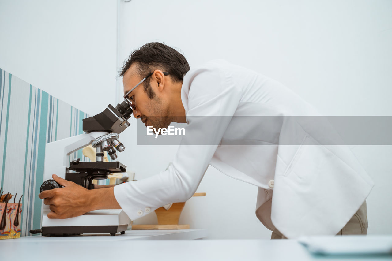 side view of young man using mobile phone in clinic