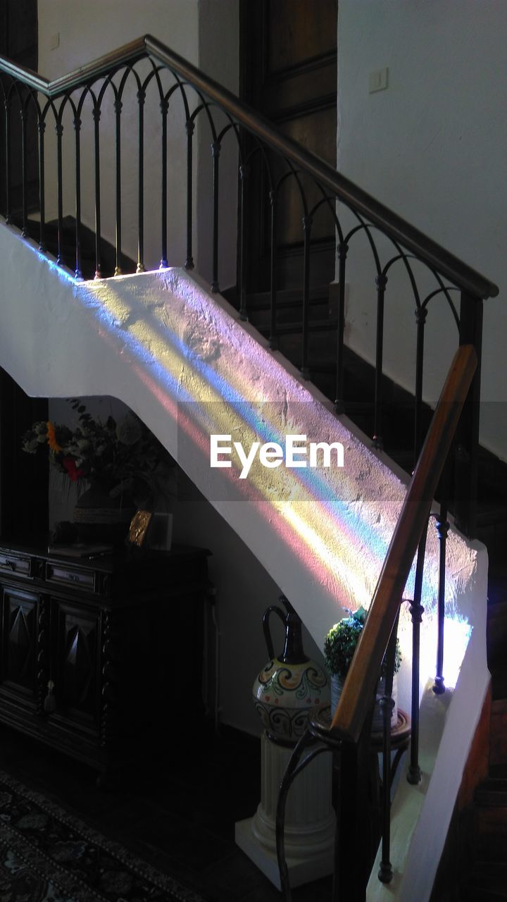 RAINBOW OVER ILLUMINATED HOUSE