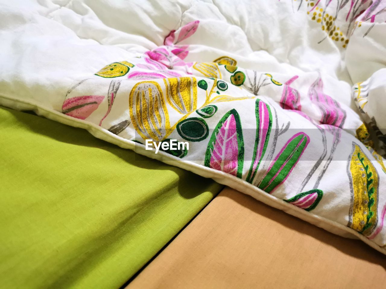 HIGH ANGLE VIEW OF MULTI COLORED BED ON FABRIC