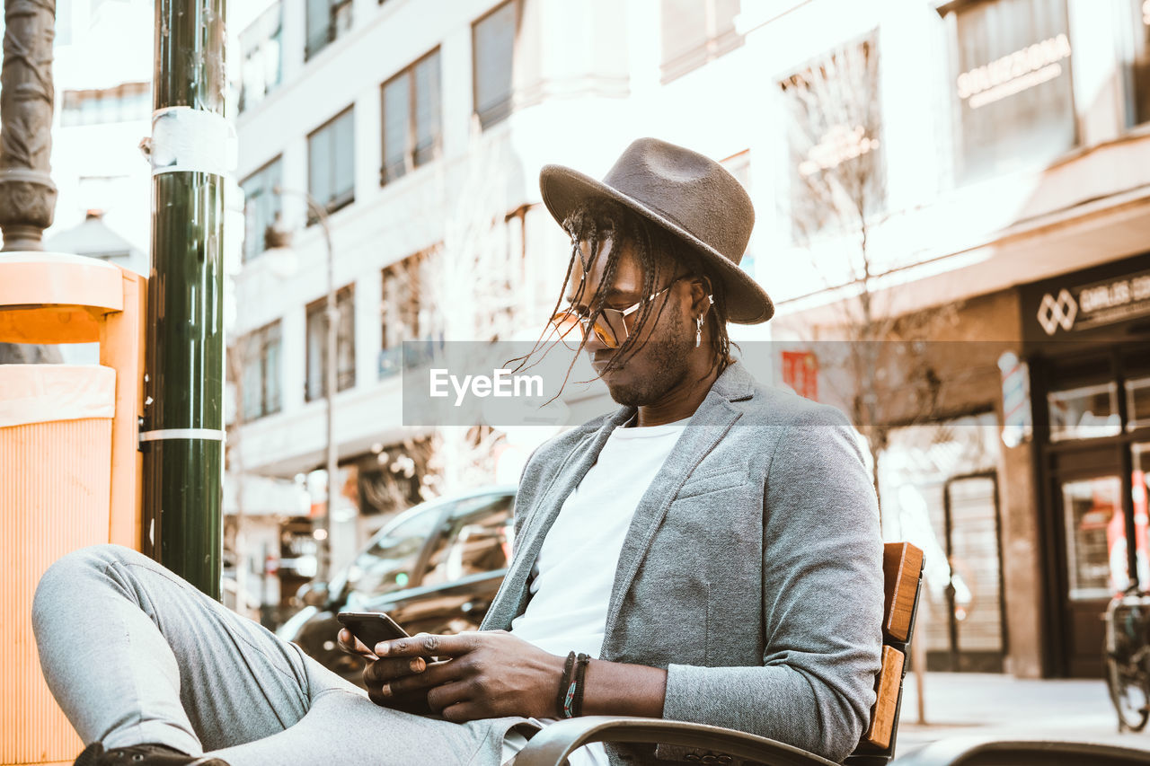Young man using mobile phone in city