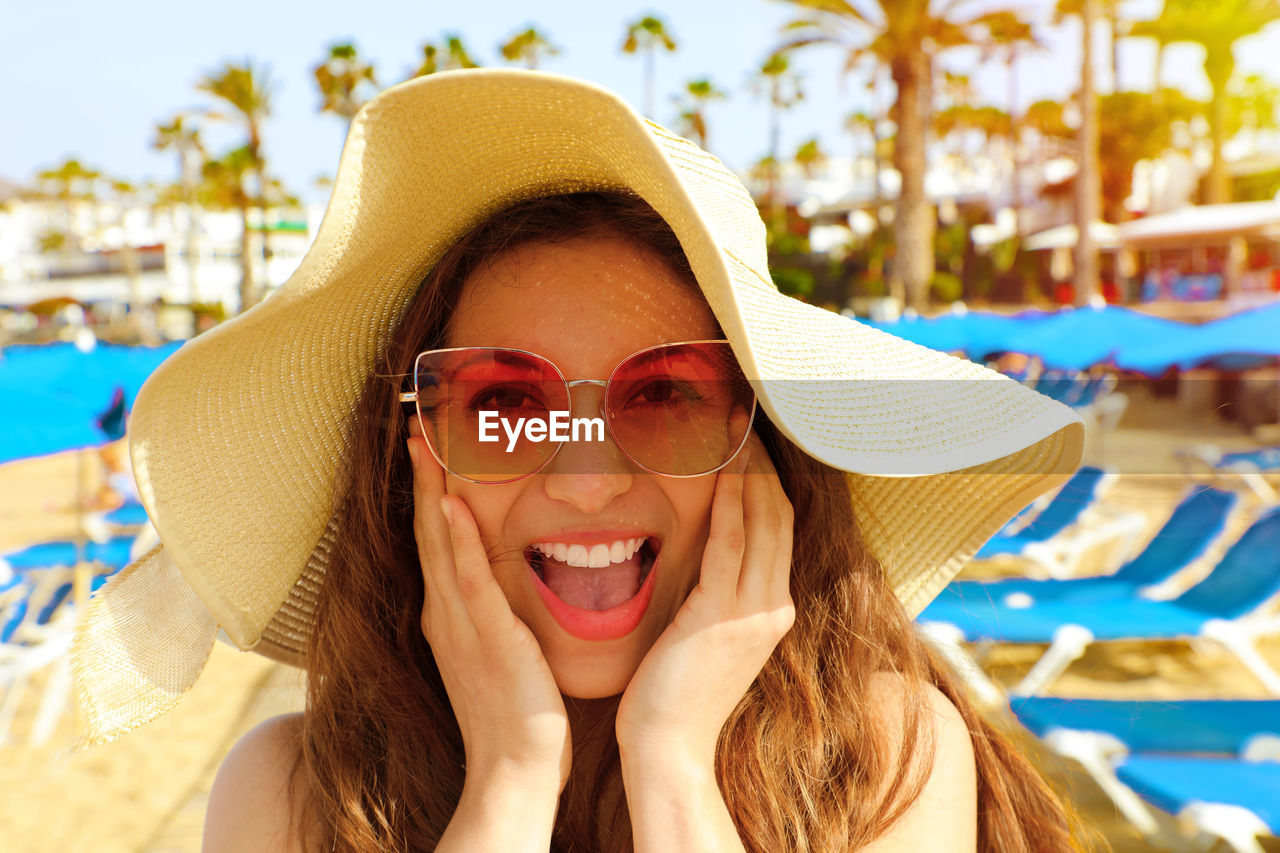 Portrait of young woman wearing sunglasses at beach