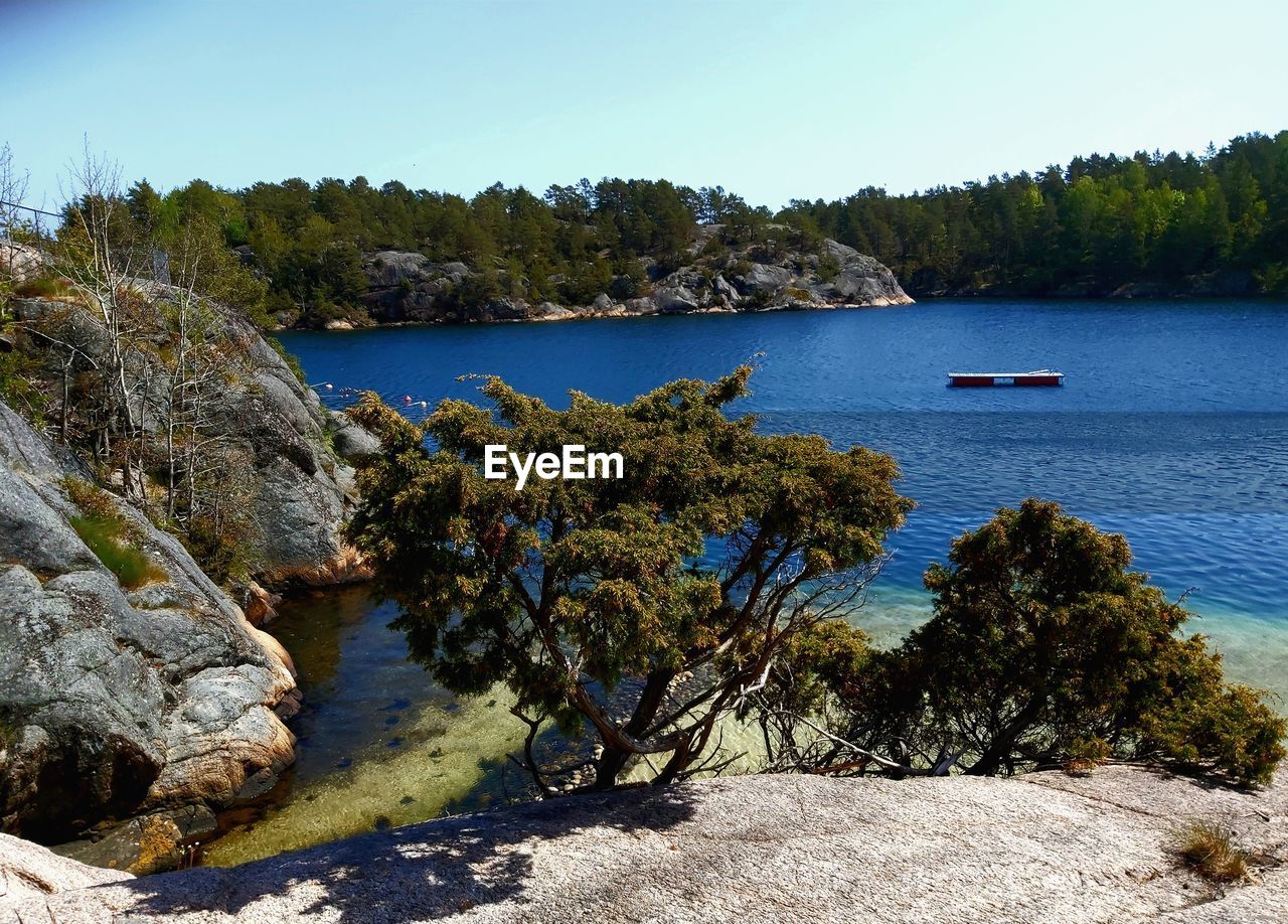 Scenic view of fjord against clear sky