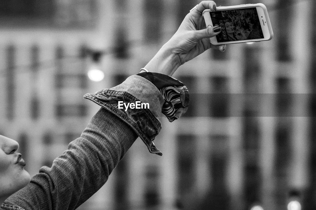 CLOSE-UP OF WOMAN HOLDING CAMERA