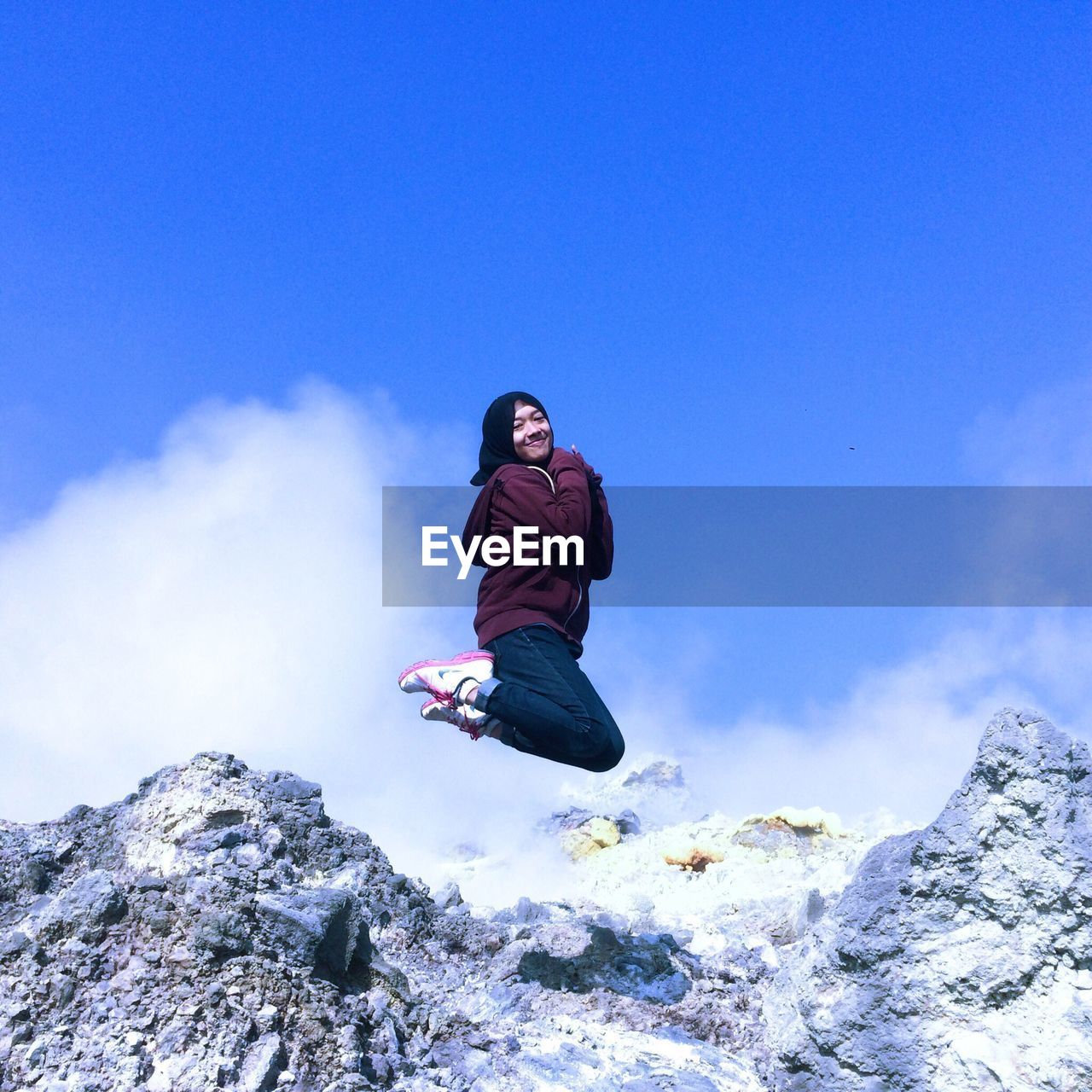 LOW ANGLE VIEW OF MAN SKATEBOARDING ON ROCK