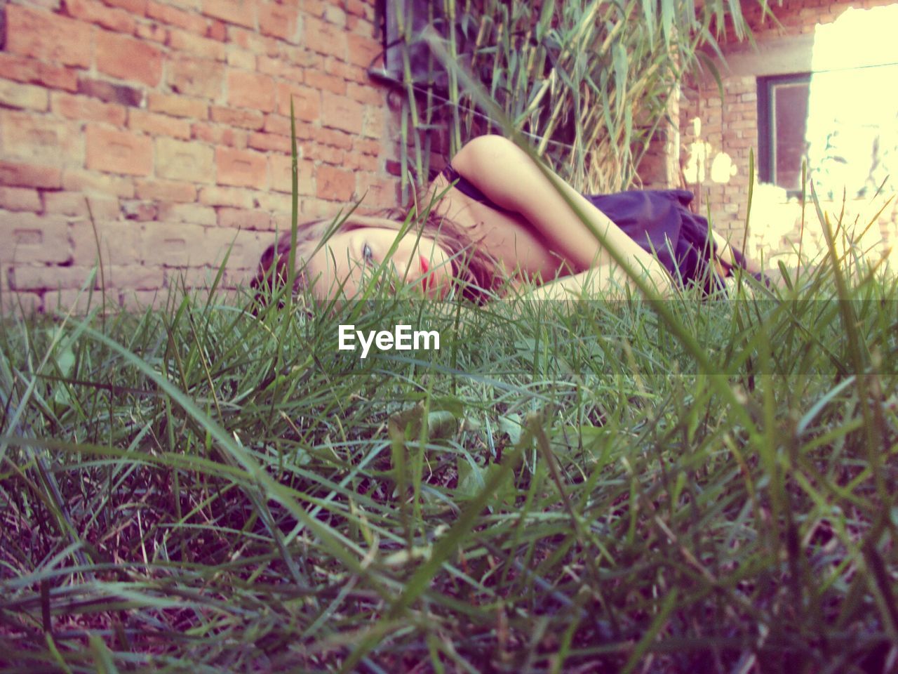 Surface level of young woman lying on grassy field