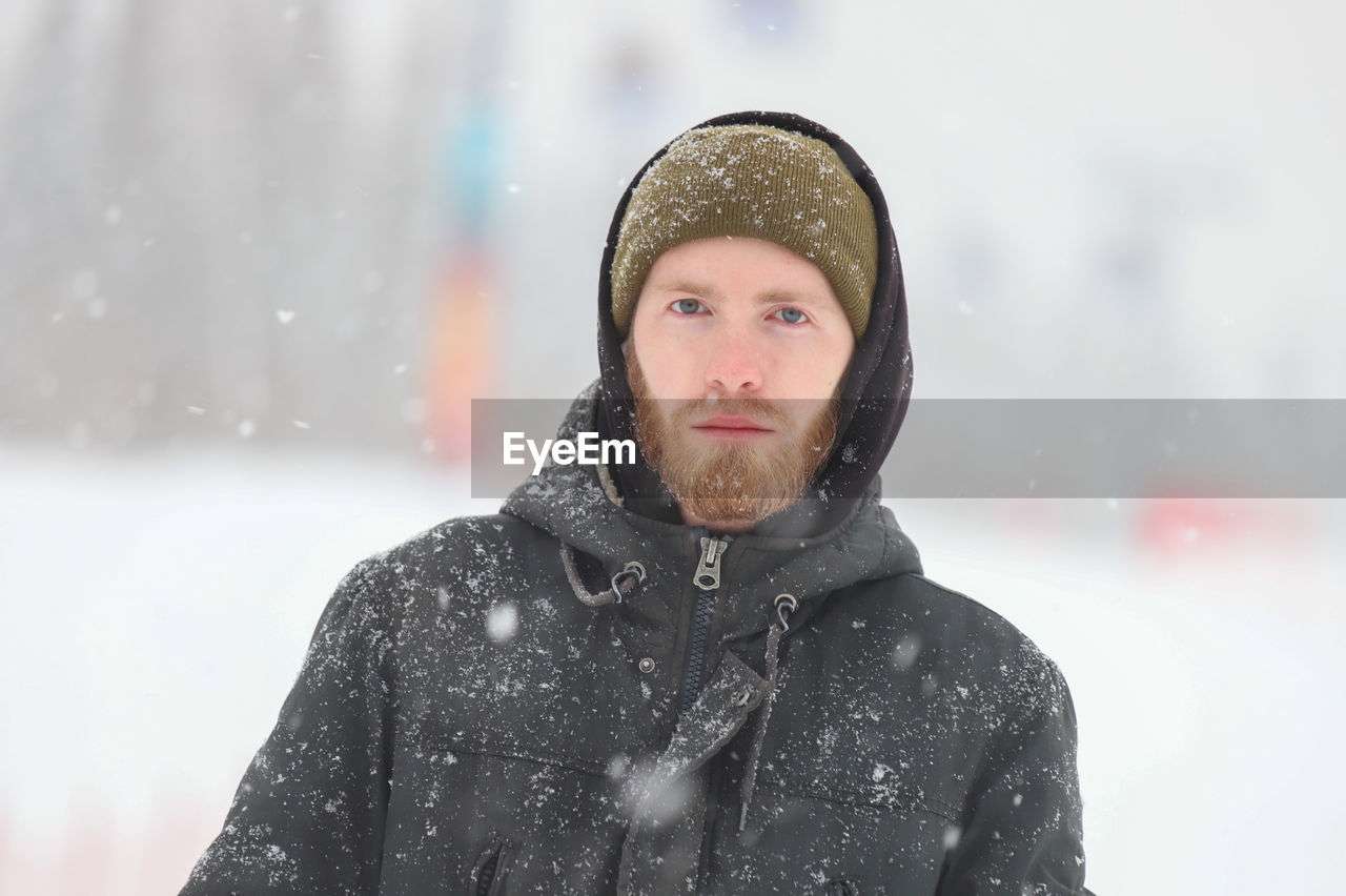 winter, cold temperature, snow, snowing, clothing, warm clothing, one person, portrait, adult, snowflake, nature, young adult, front view, men, hat, storm, beard, hood, freezing, coat, blizzard, headshot, looking at camera, knit hat, facial hair, extreme weather, leisure activity, hood - clothing, outdoors, emotion, environment, human face, sports, looking, winter storm, winter coat, day, frozen, waist up, serious, focus on foreground, lifestyles, jacket, copy space, person, happiness, smiling, beauty in nature