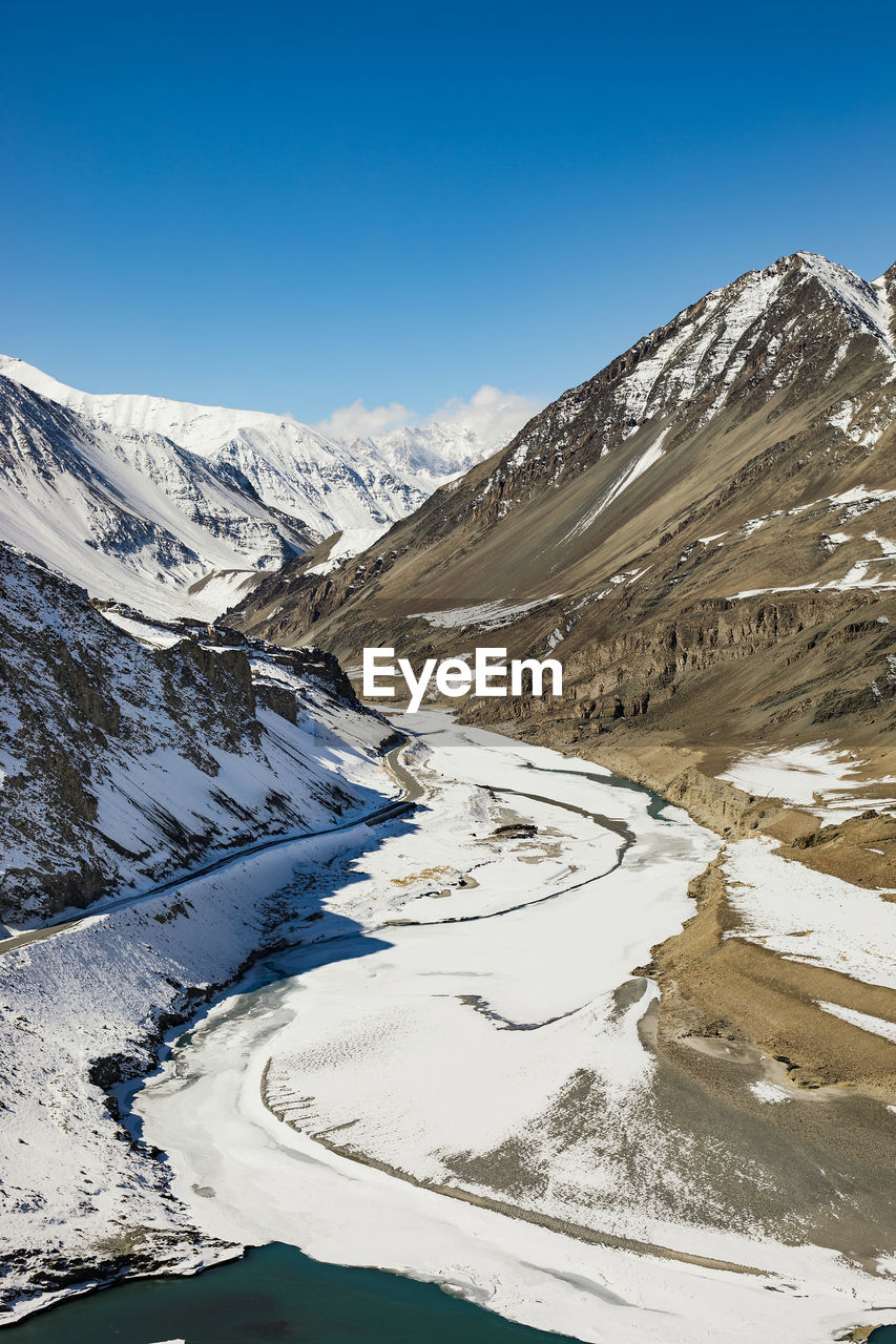 SNOWCAPPED MOUNTAINS AGAINST BLUE SKY