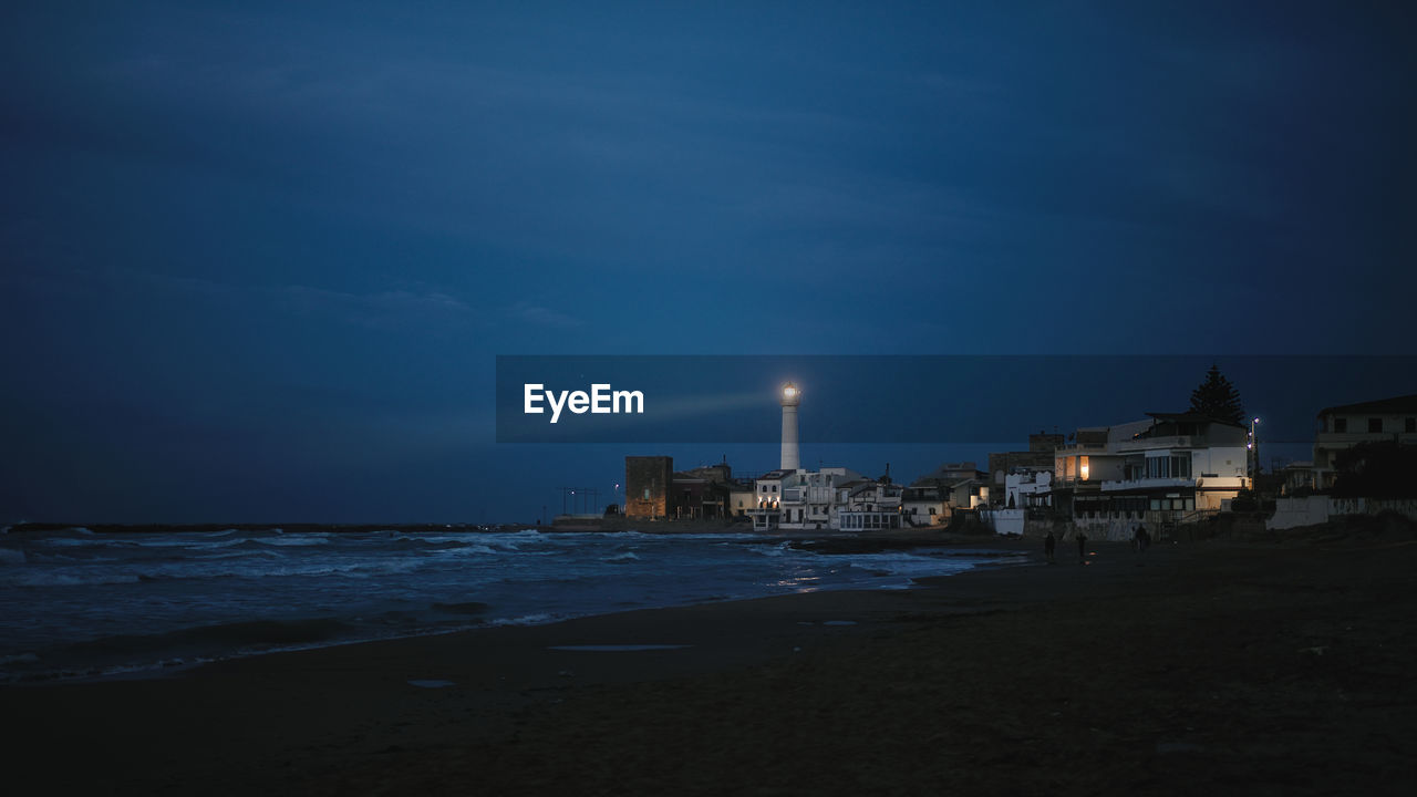 Lighthouse on the beach in the night