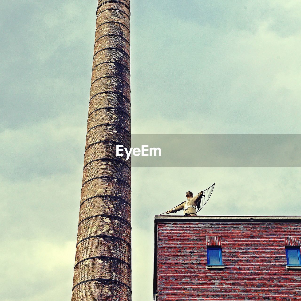 LOW ANGLE VIEW OF BIRD PERCHING ON BUILDING