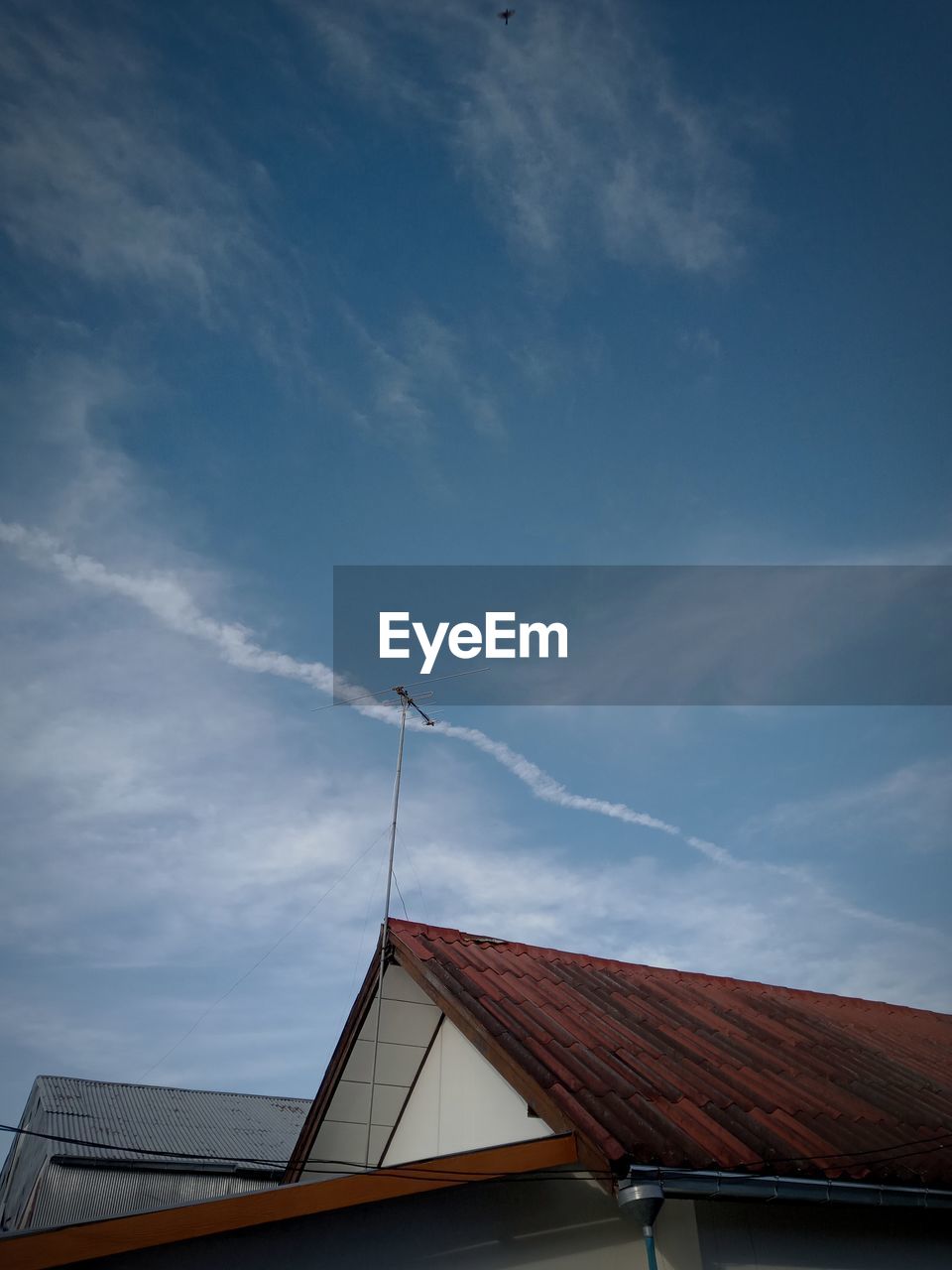 Low angle view of house roof against sky