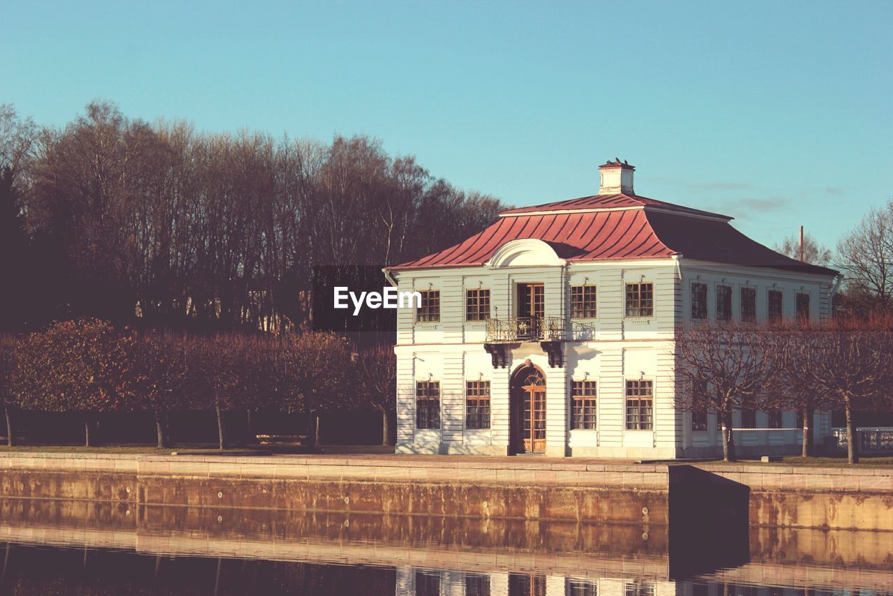 Building by lake against sky