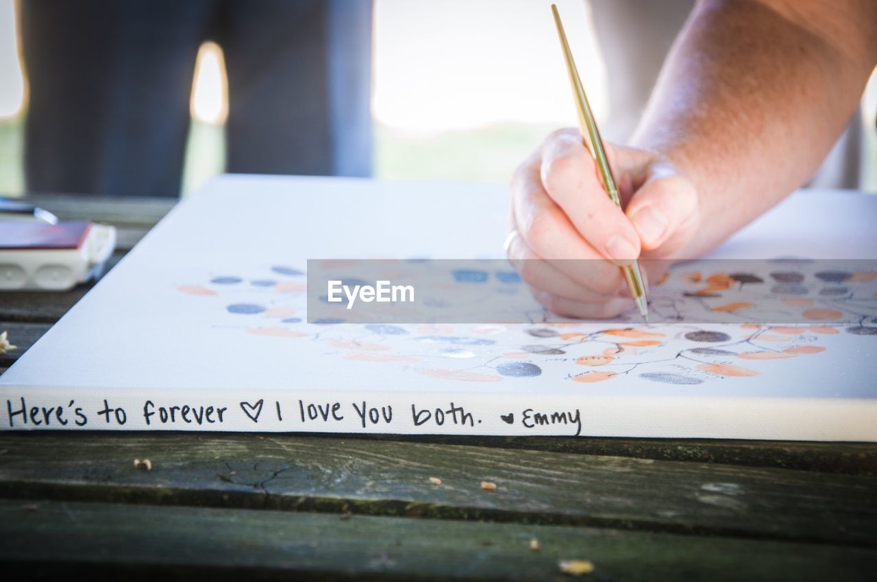 Close-up of hand writing on book