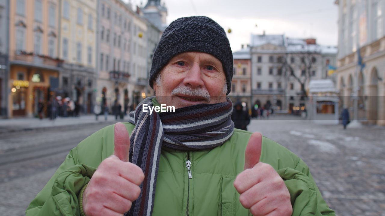 Portrait of man standing in city during winter