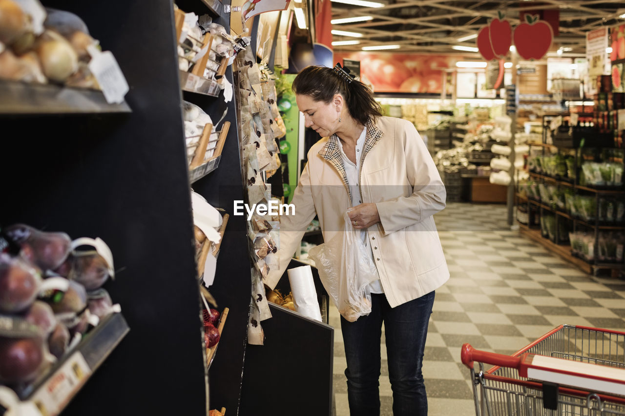 Woman shopping while standing in supermarket