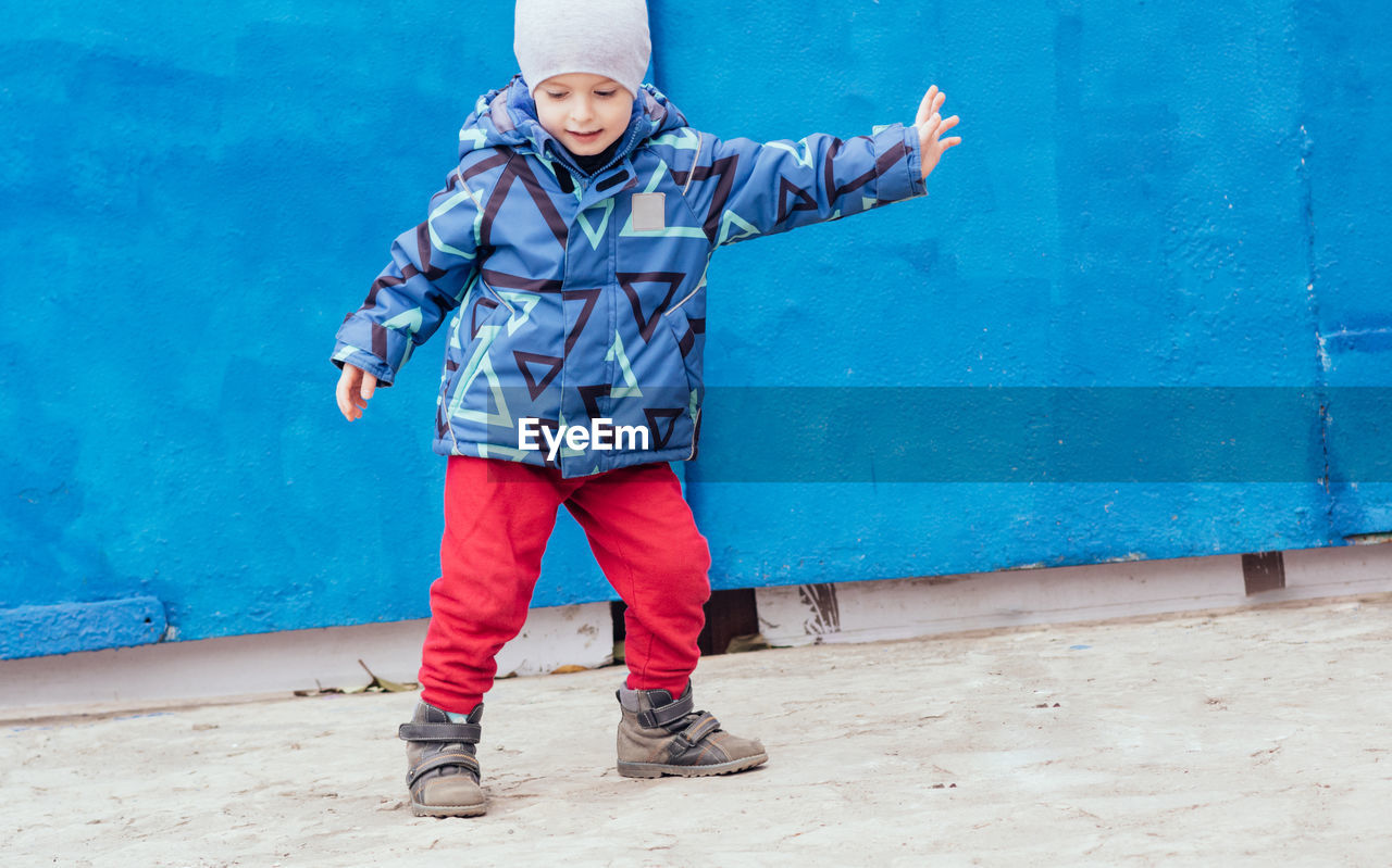 A cheerful child outdoors expresses himself through movement. power, joyful, rhythm, emotion. 