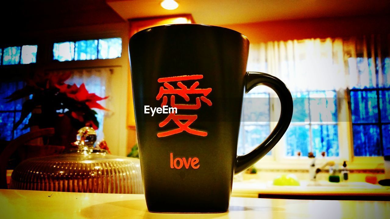 Mug with love written on table at home