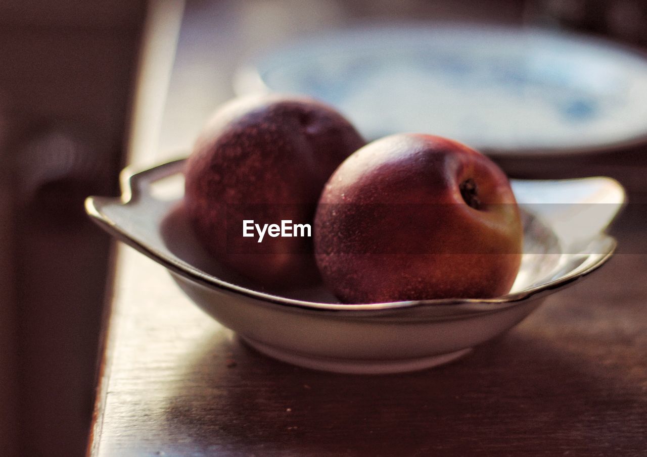 Close-up of apples in bowl on table