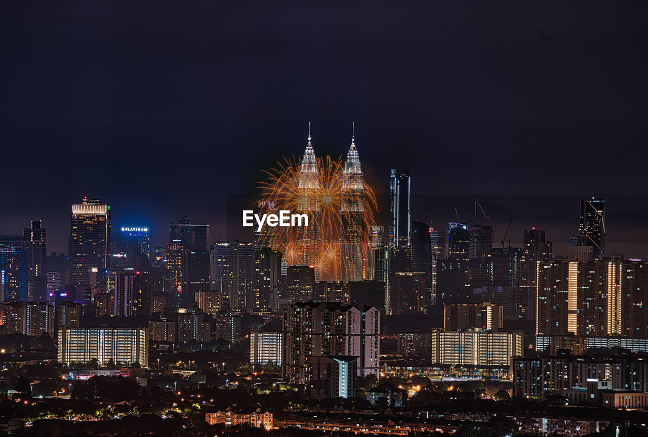 ILLUMINATED MODERN BUILDINGS IN CITY AT NIGHT