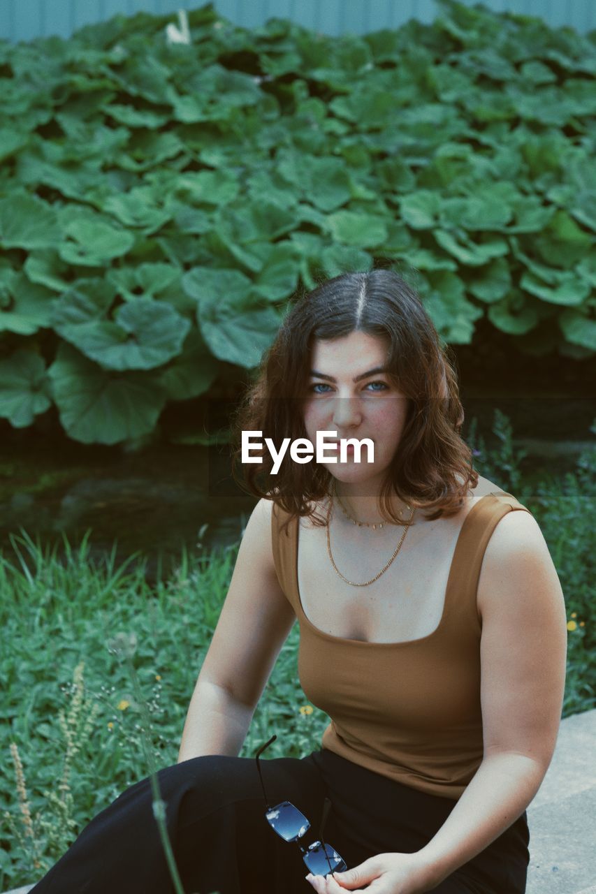 PORTRAIT OF BEAUTIFUL YOUNG WOMAN WITH PLANTS