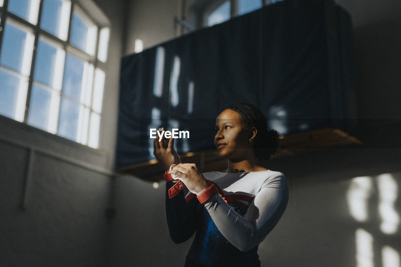 Contemplative teenage girl standing in school gymnasium