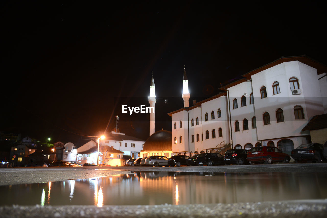 ILLUMINATED BUILDINGS AGAINST SKY AT NIGHT