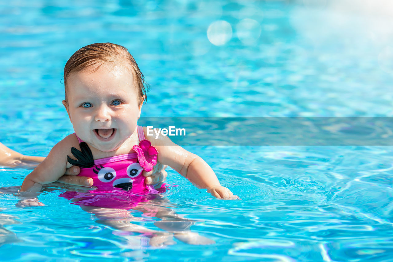 Portrait of cute baby girl in swimming pool